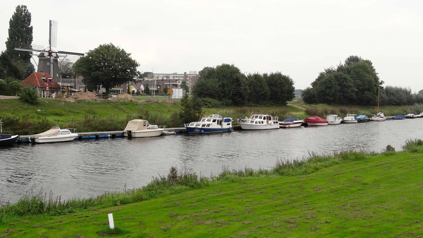 De Vecht bij Ommen met groene oevers, boten en een molen langs het water.